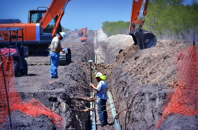 Men surveying waterline pipeline installation
